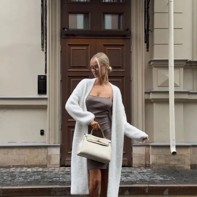 White oversized knitted cardigan jacket with long sleeves on a model.