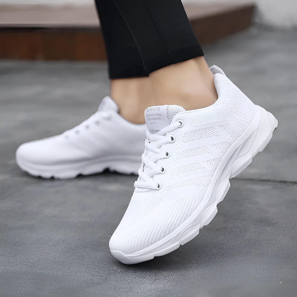 Women's sports running shoes in white with mesh and Flyknit upper, flat heel, and lace-up front