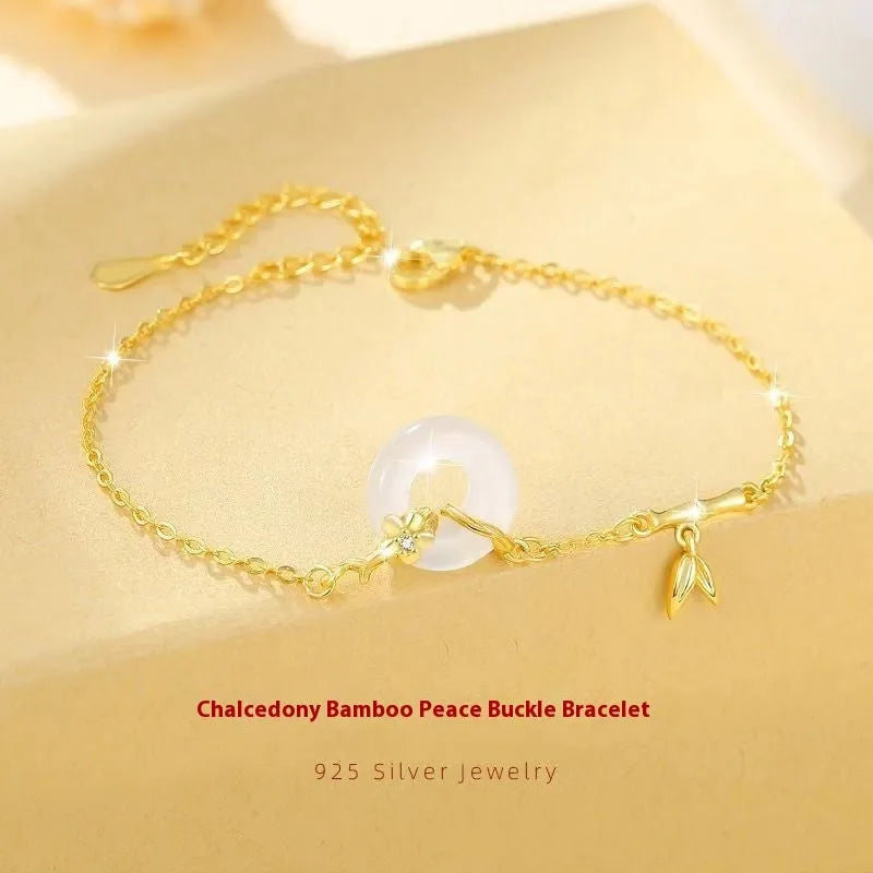 Silver gold electroplated women's bracelet with a white chalcedony stone and prominent peace buckle clasp on a 22 cm band.