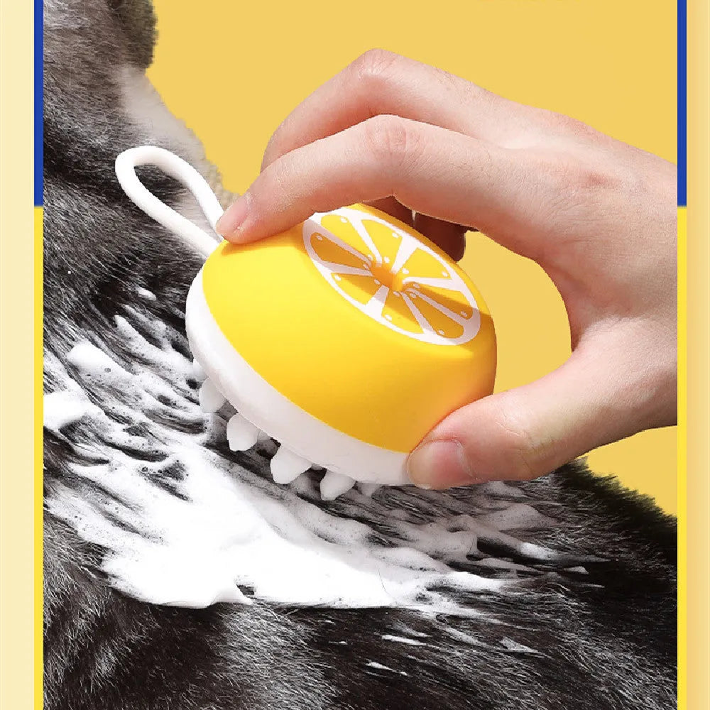Yellow silicone pet bath brush and grooming comb tool held in a hand.