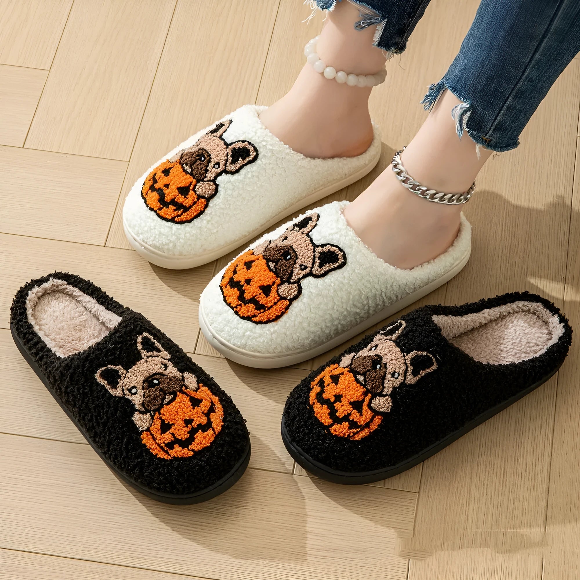 Black and white Halloween plush slippers with pumpkin design, round toe, and textured non-slip TPR soles.