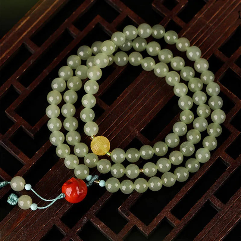 Pale blue Hetian jade bracelet with three circles of 6mm beads on a wrist.