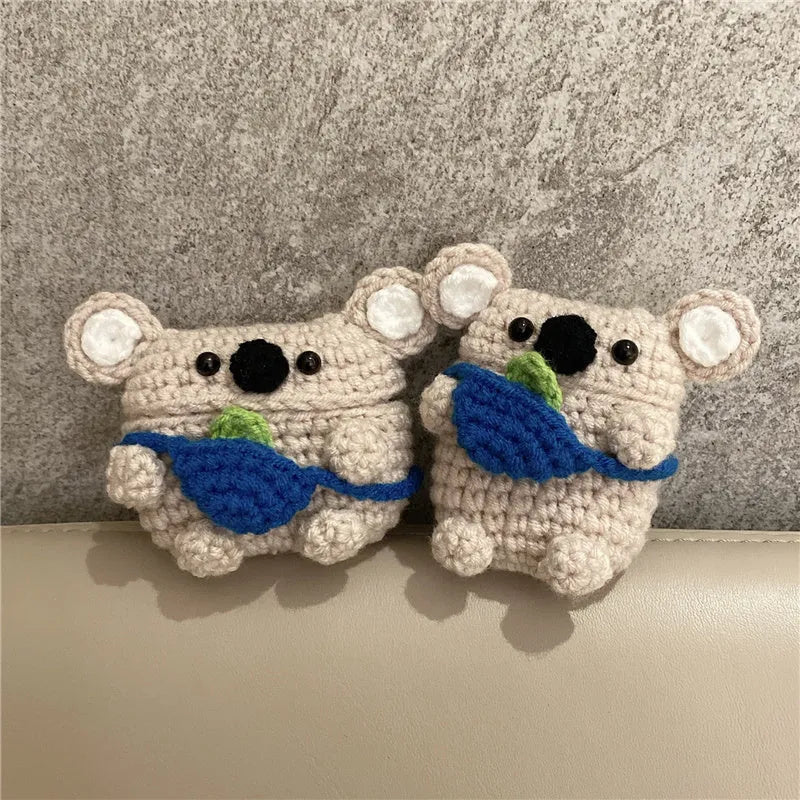 Handmade knitted koala bear backpack-shaped cover for an AirPods charging case.