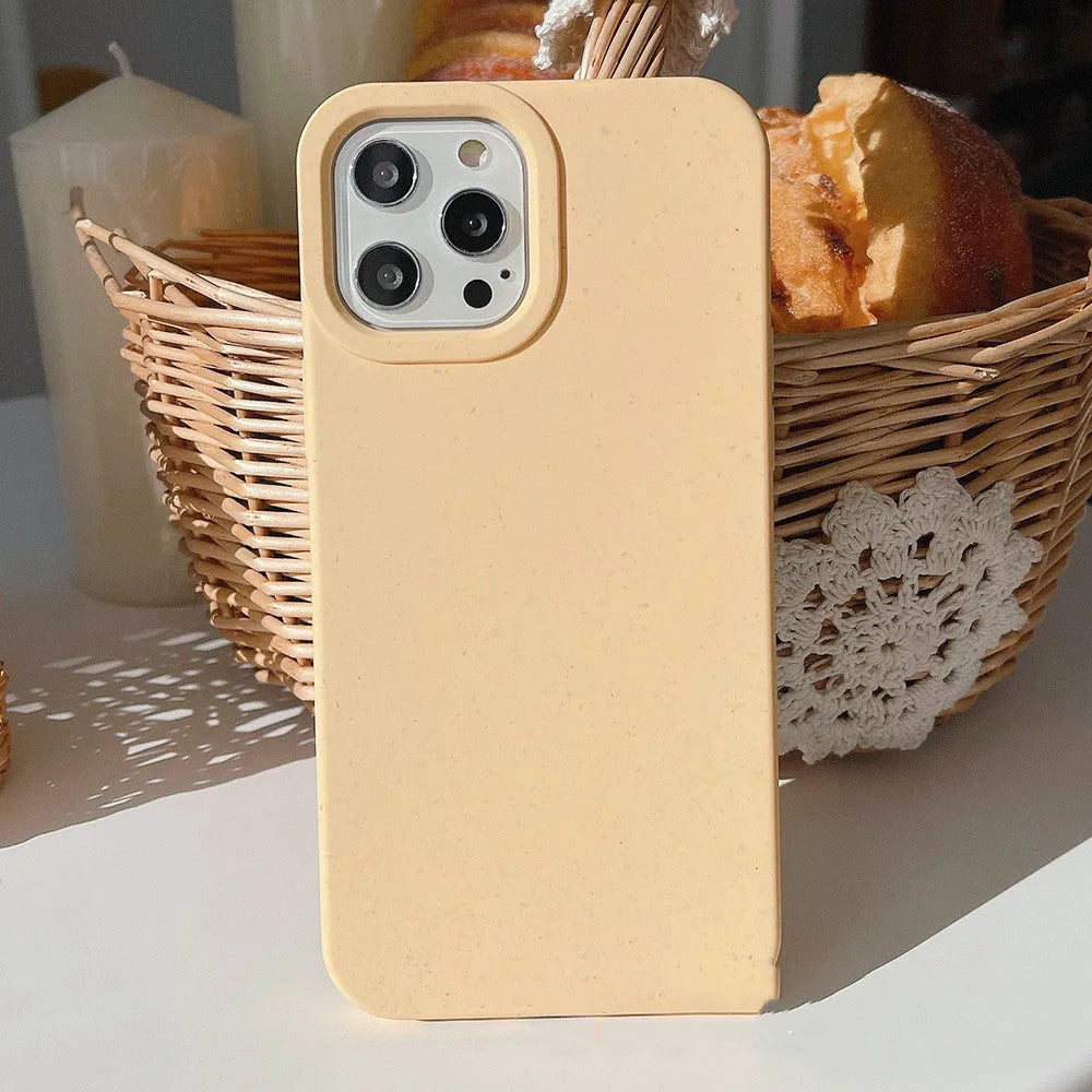 A degradable wheat straw phone case for iPhone on a wooden surface, showing its rear cover design.