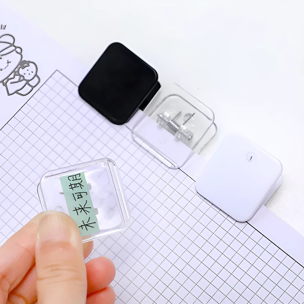 Set of five small square plastic note holders in white, black, and transparent colours