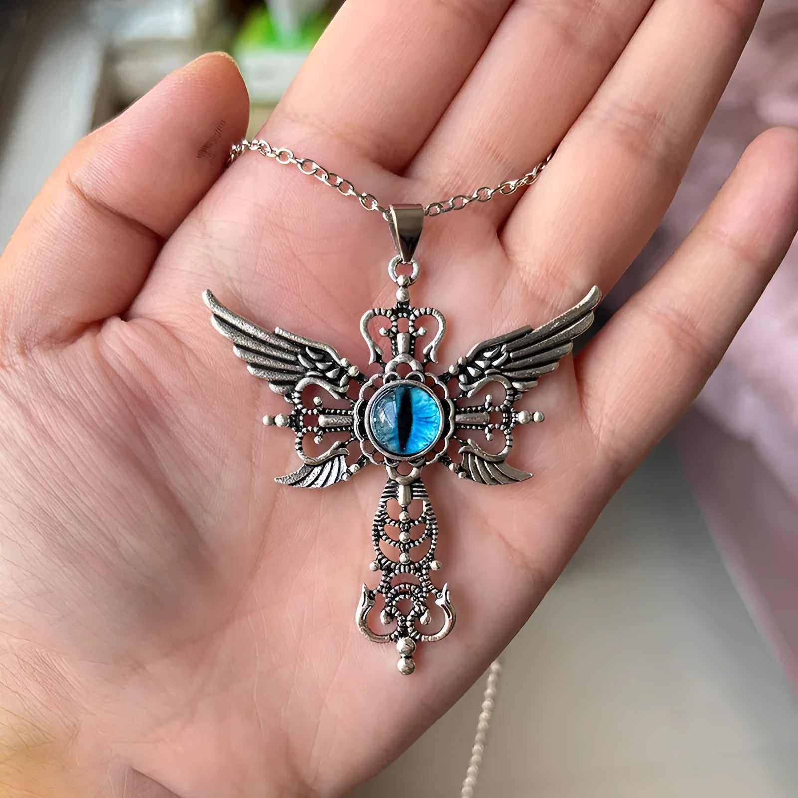 Geometric devil wings and cross alloy pendant necklace on a chain, shown in blue, green, purple, red, and yellow colour variants.