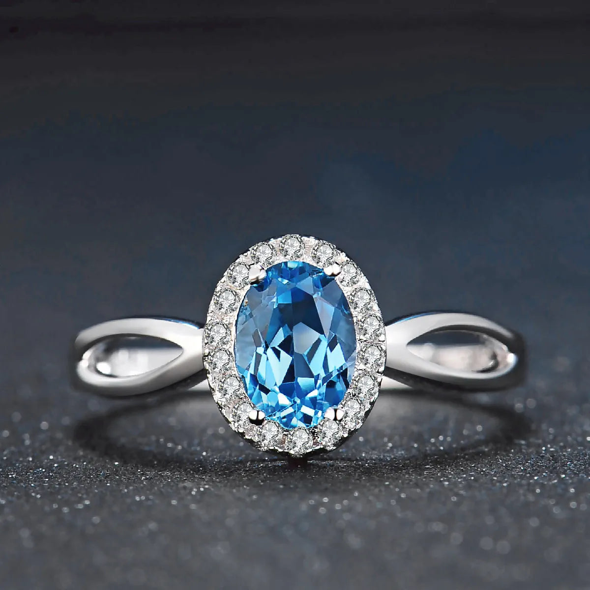 Women's four-piece sterling silver jewellery set with blue topaz gems, showing geometric earrings, ring, pendant and necklace.