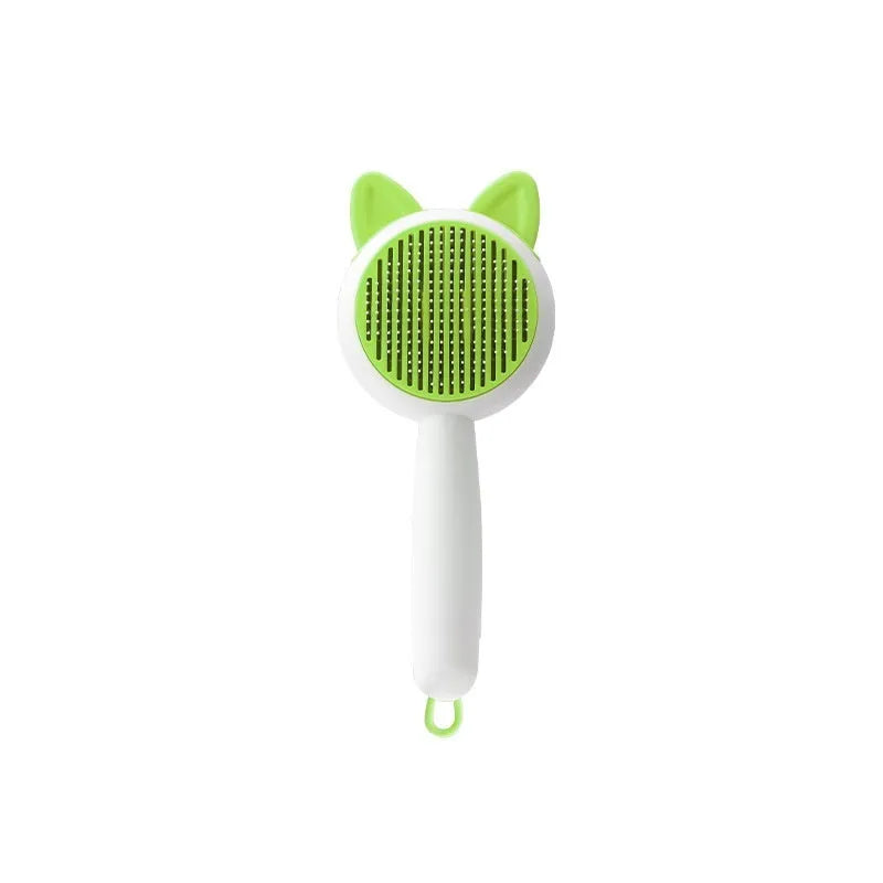 Greenish white cat grooming brush with stainless steel teeth and a self-cleaning button on the handle.