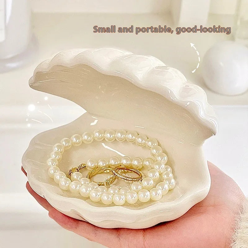 Yellow and white porcelain shell-shaped tray with integrated small LED night light on a wooden surface.