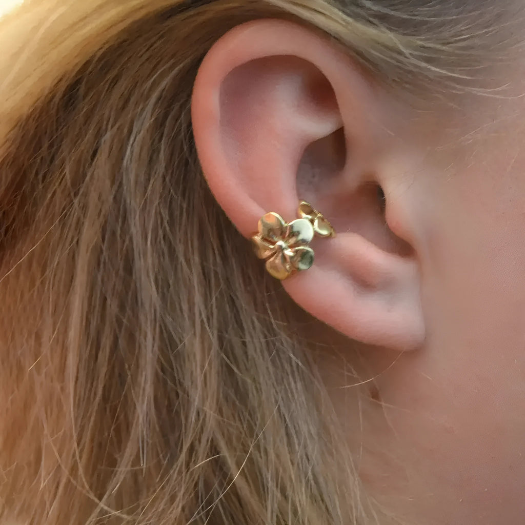 Gold-coloured alloy earrings with starfish and conch designs on a white background.
