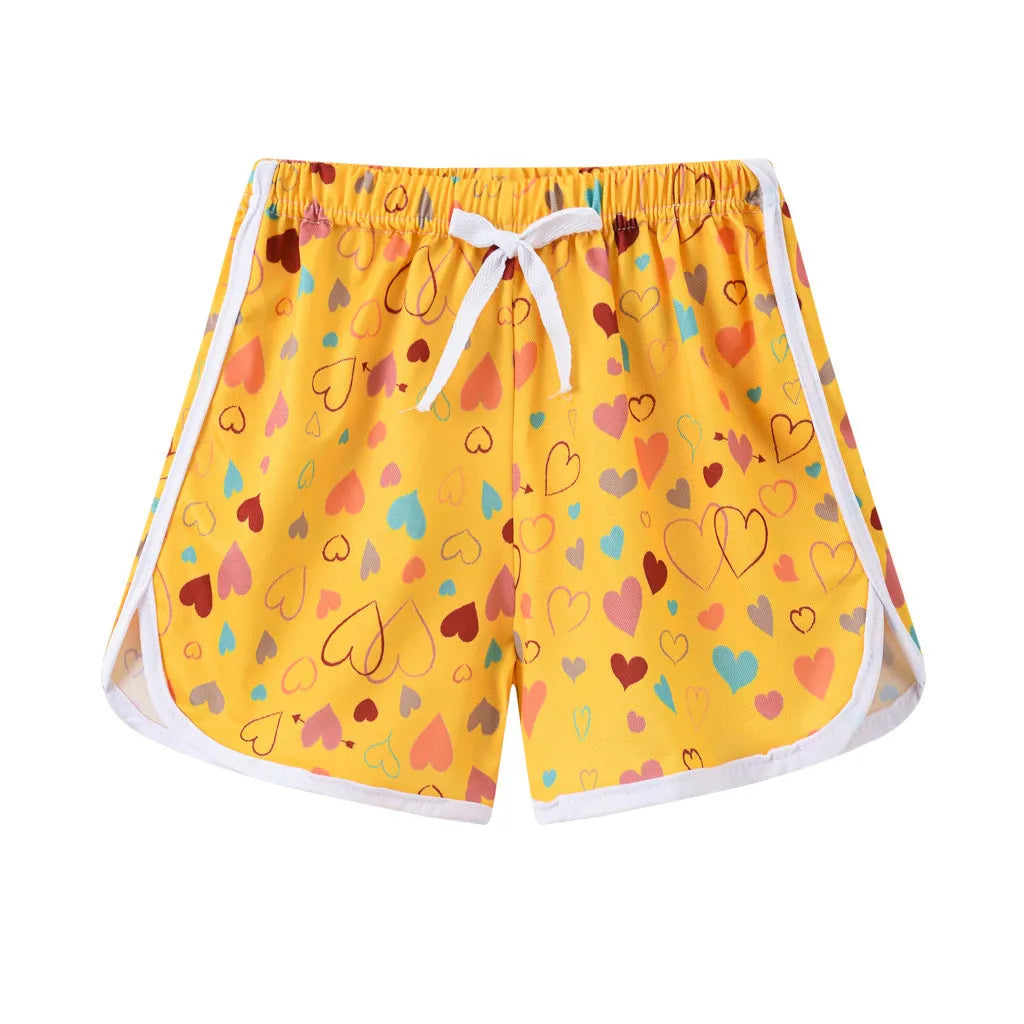 Children's polyester shorts in assorted colours and prints including pineapple, kitten, and stripe designs.