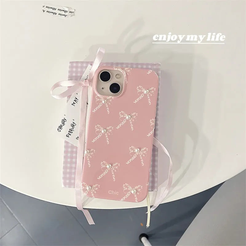 Pink soft TPU iPhone case with three-dimensional pearl dot bow, compatible with iPhone 11 to 15 Pro Max.