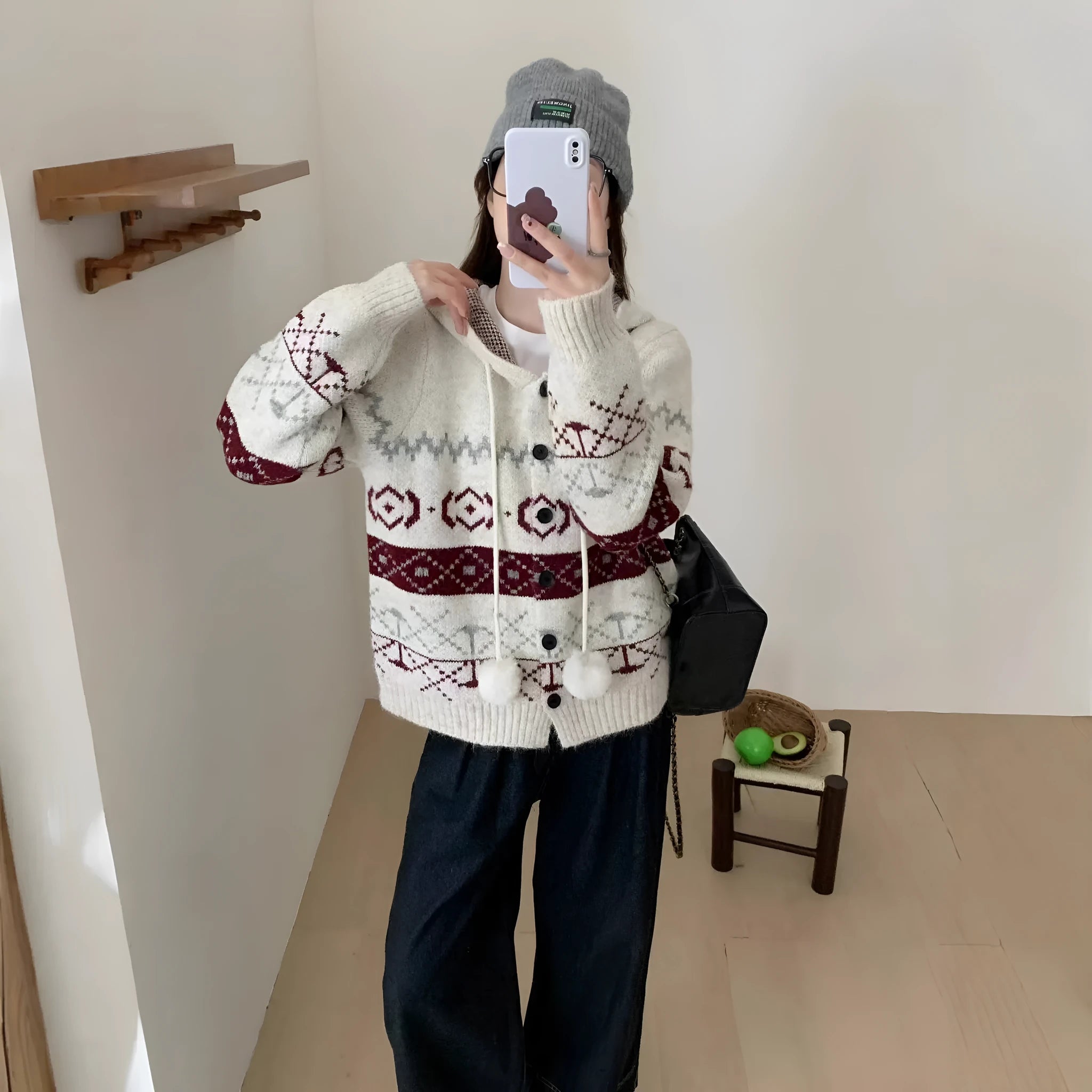 Plus size woman wearing a loose, geometric patterned grey acrylic sweater coat.