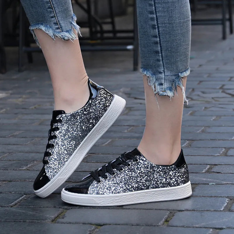 Women's black low-top casual shoes with sparkling sequinned upper and white laces.