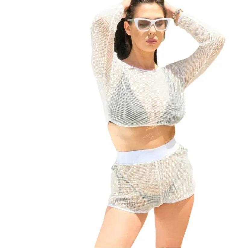 White transparent mesh women's swimsuit top and skirt set on a beach.