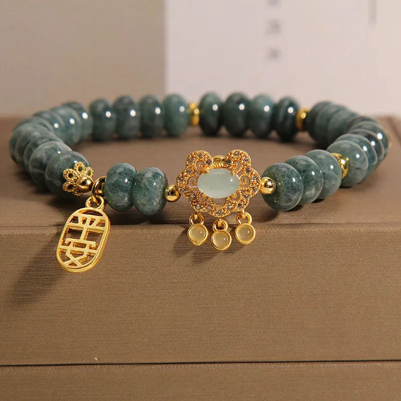 Women's bracelet with green jade abacus beads and a metallic safety lock clasp.