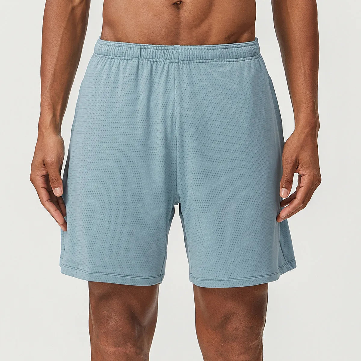 Man wearing sky green double-layer men's running shorts with a mid-waist fit.