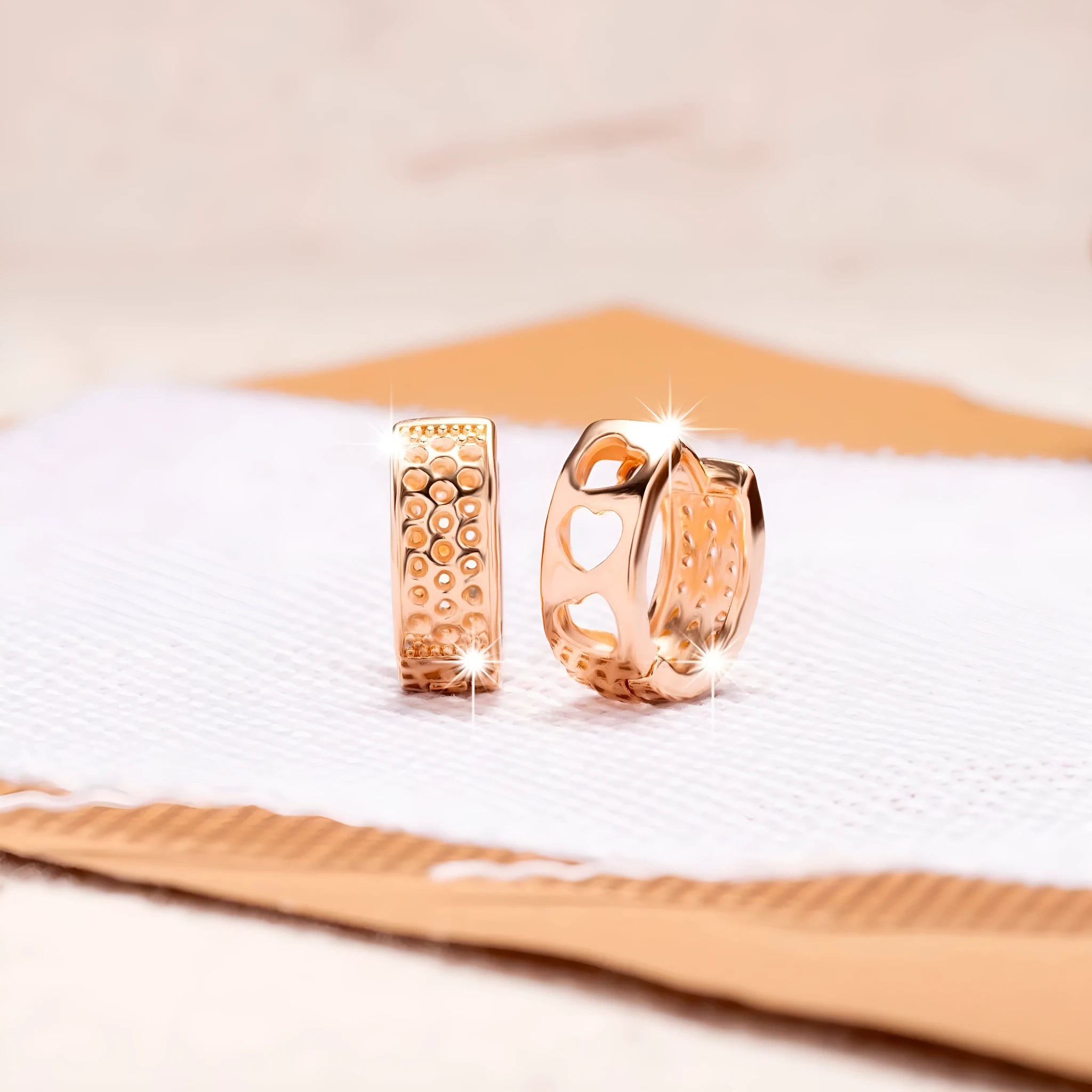 Pair of rose gold women's earrings with a 1.5cm hollow heart shape and three smaller heart cut-outs.