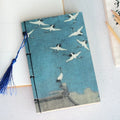 Antique wire-bound notebook with historical artwork cover and decorative tassels