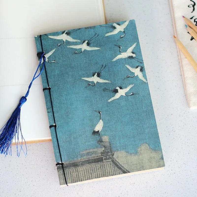 Antique wire-bound notebook with historical artwork cover and decorative tassels