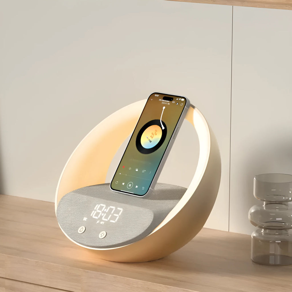 Beige multifunctional wireless charging Bluetooth speaker with clock and adjustable LED mood lighting on a wooden table.