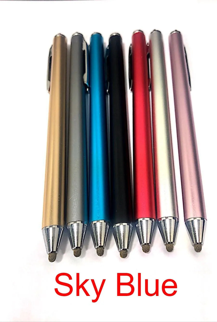 A black metal stylus with a fine point tip positioned next to a mobile phone and tablet on a desk.