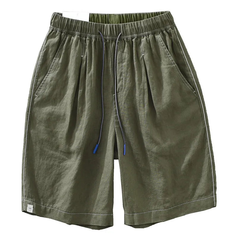 Men's loose fit linen shorts in green, showing straight drooping leg and drawstring waist.