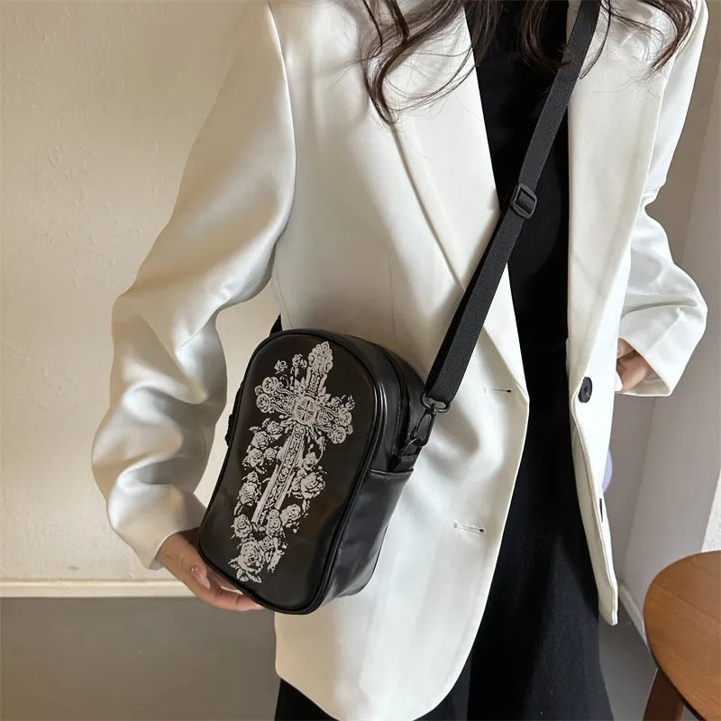 Black mini square crossbody bag with orange pumpkin, white ghost, and black bat graffiti print on the front.