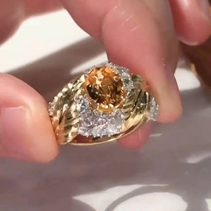Gold women's ring with embossed feather pattern and yellow zircon stones on geometric copper band