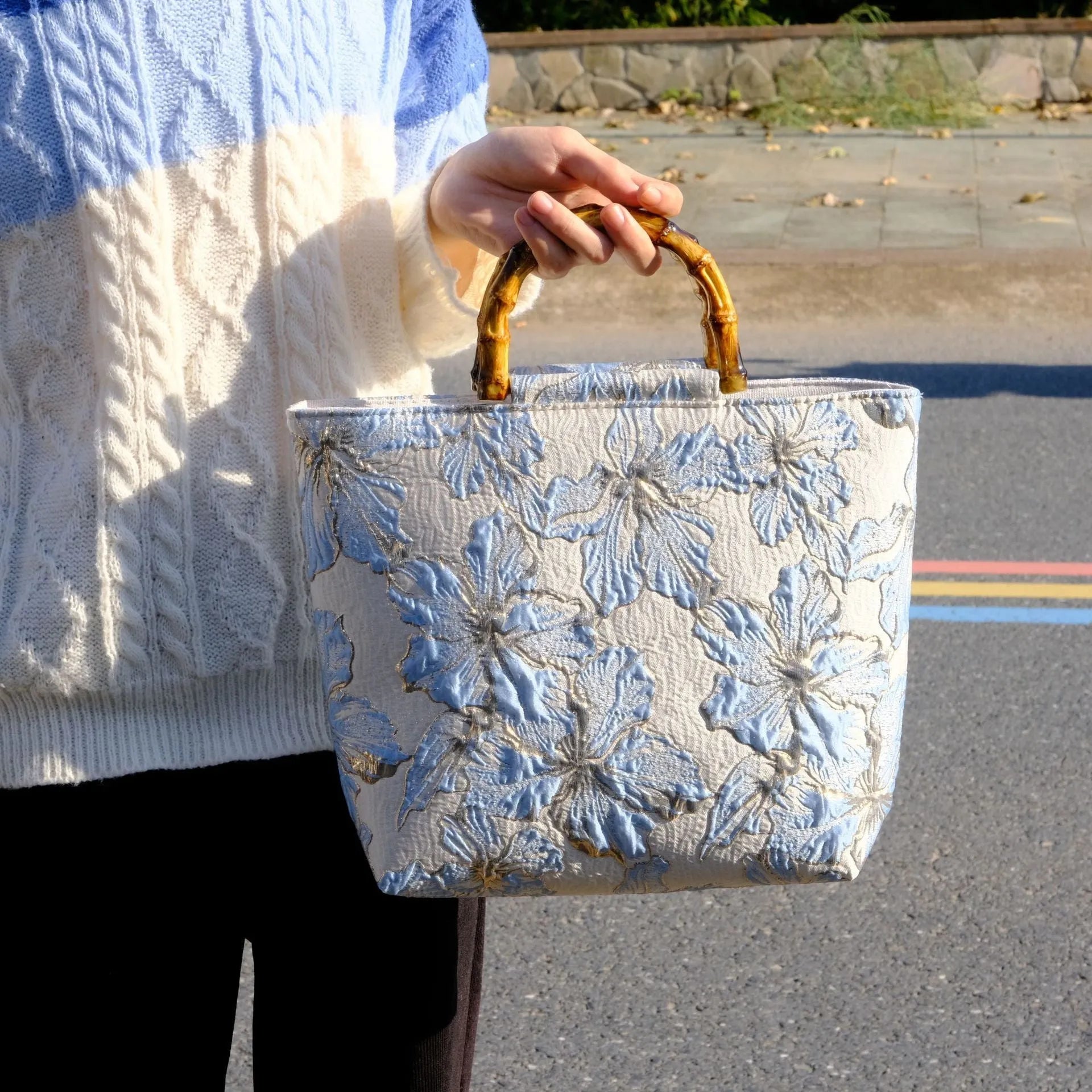 Light blue women's canvas bag with gold bronzing flower pattern showing double shoulder straps and square shape