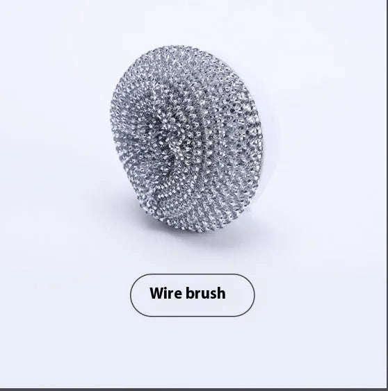 White and grey cordless electric spin scrubber cleaning brush with four attached brush heads on a table.