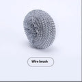White and grey cordless electric spin scrubber cleaning brush with four attached brush heads on a table.