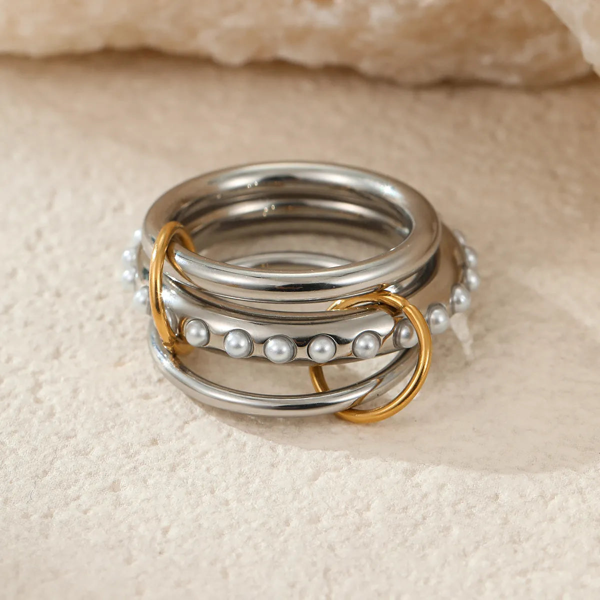 Stacked colour matching stainless steel ring with 18K gold plating on a hand.