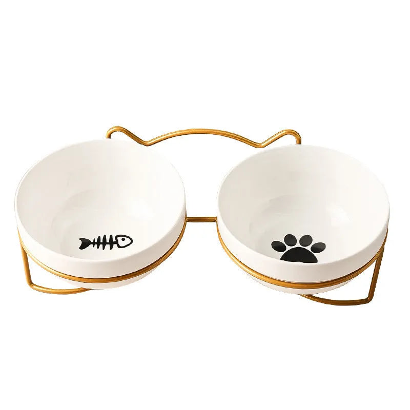 White ceramic cat bowl with cat footprint design on a black iron stand with cat ears.