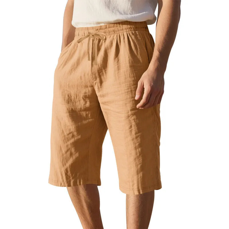 Man wearing light blue linen casual shorts with a cropped length and high waist.