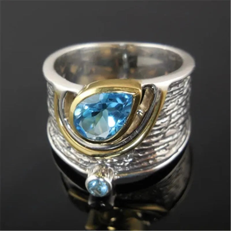 Blue drop-shaped zircon ring with Chinese-style design on a model finger.