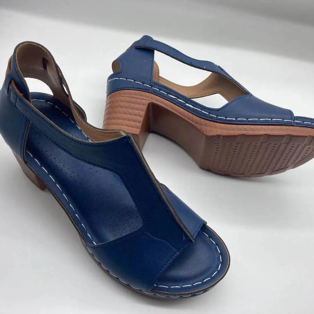 Women's beige peep toe wedge sandals with a buckle strap, shown on a foot.