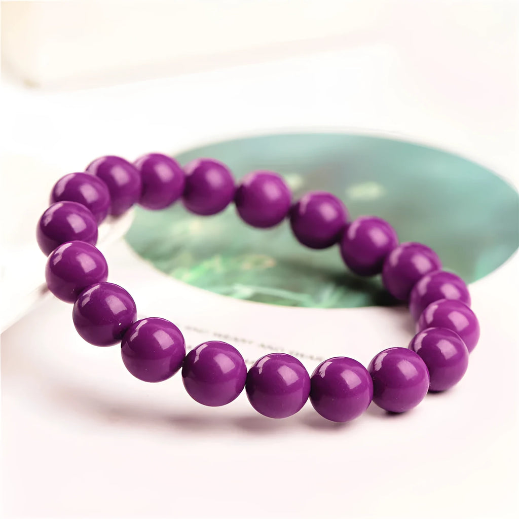 Jiuya brand purple mica crystal bracelet with polished beads on a wrist.