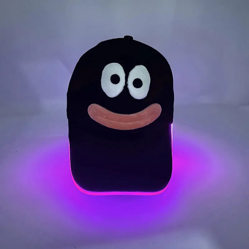 Black Halloween baseball cap with LED pumpkin smile face and yellow lights illuminated.