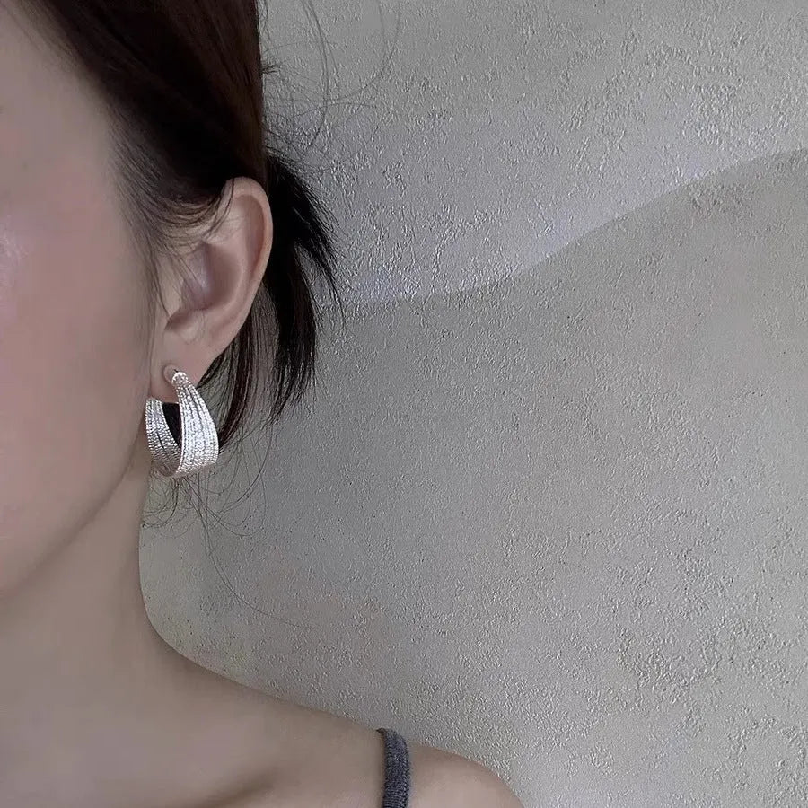 Geometric multi-layer copper earrings with silver or gold electroplated finish, available as studs or clips