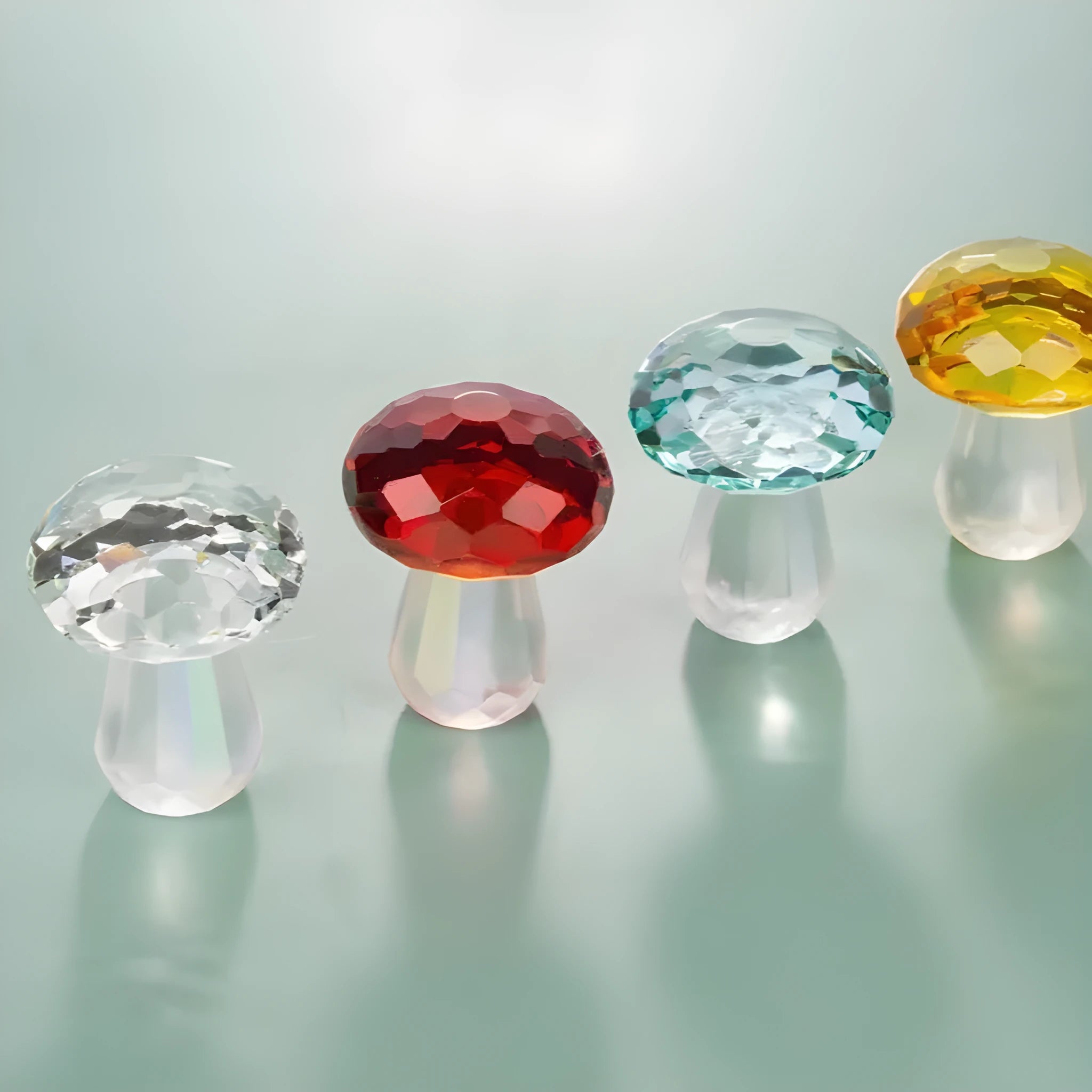 Handcrafted white crystal mushroom decoration in four colours on a wooden surface.