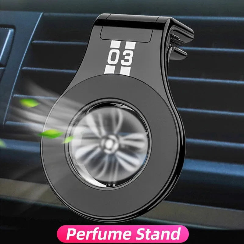 Black magnetic car phone holder mounted on a car air vent, showing 360-degree rotation and fragrance slot.