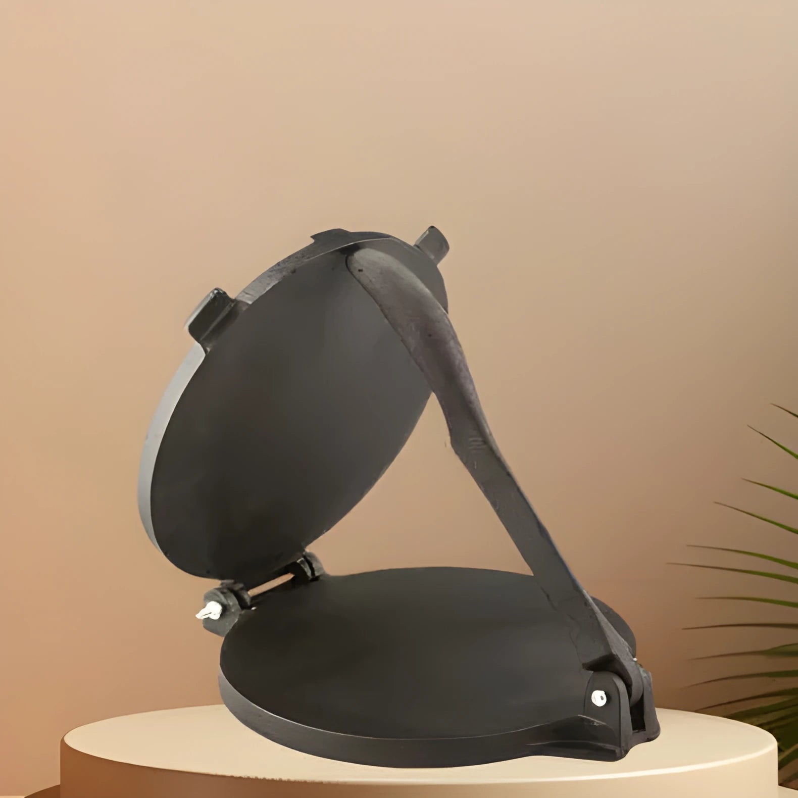 Round cast iron hand pressure cake press on a kitchen surface, available in sizes 16.5cm to 26cm diameter