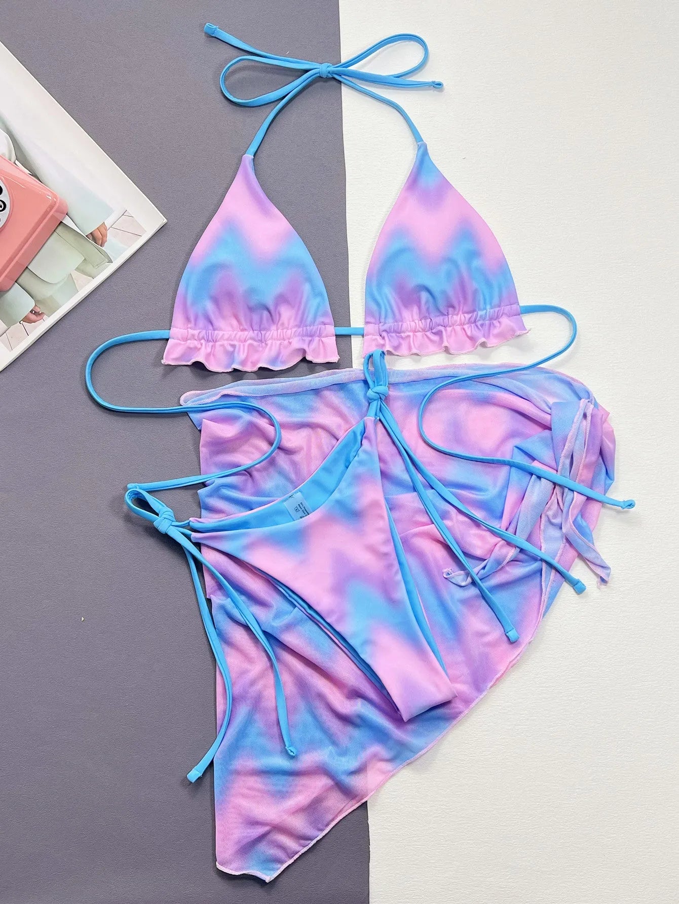 Women's split tie-dye bikini swimsuit set with matching skirt on mannequin