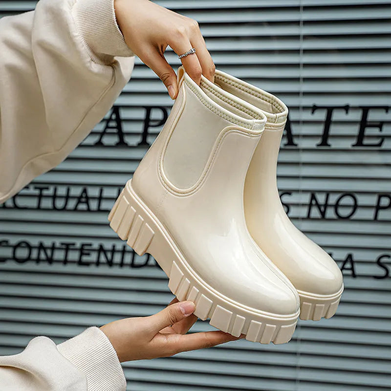 Women's creamy white PVC low tube rain boots with a flat heel on a white background.