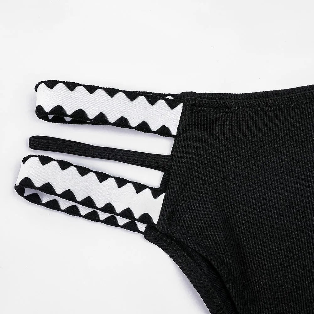 Black women's one-piece swimsuit with hollowed-out split design and briefs cut.