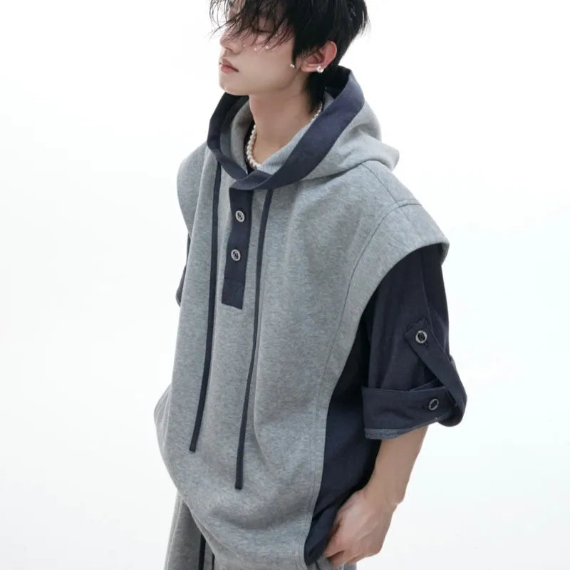 Man wearing a black hooded short sleeve sports jacket with textured stitching and matching full-length trousers.