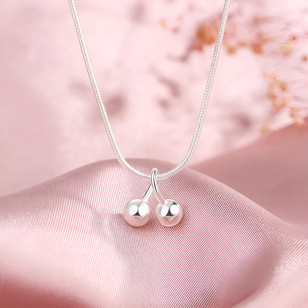 Silver cherry fruit pendant necklace on an adjustable snake bone chain for women.