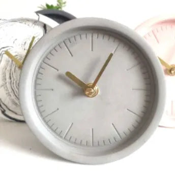 Round cement silent desk clock with Nordic minimalist design on wooden surface