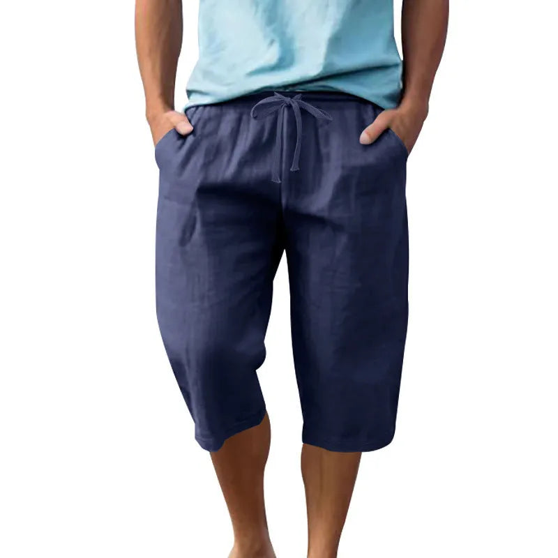Man wearing light blue linen casual shorts with a cropped length and high waist.